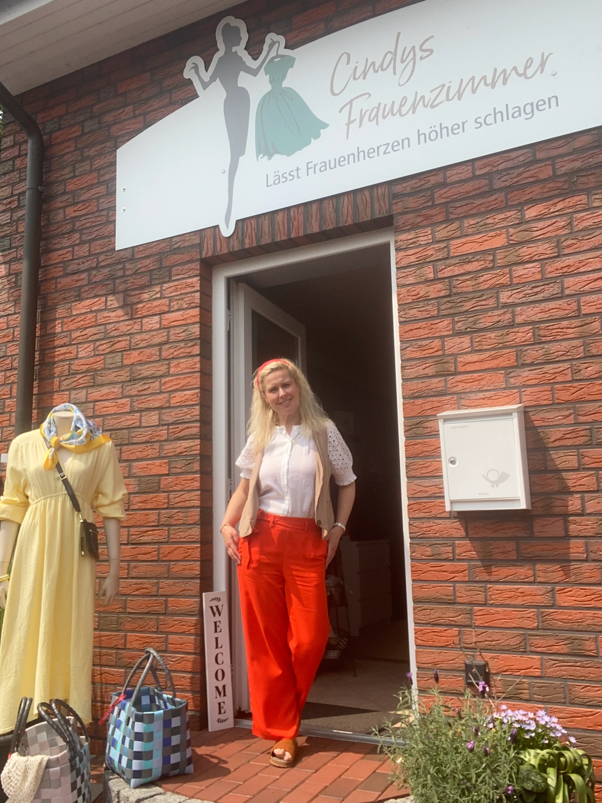 Cindy steht vor dem Eingang ihres Modegeschäfts Cindys Frauenzimmer in Bispingen